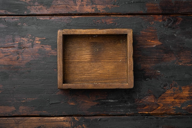 Boîte ou conteneur en bois rustique avec espace de copie pour le texte ou la nourriture, vue de dessus à plat, sur un vieux fond de table en bois foncé