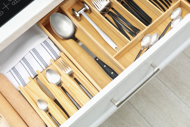 Boîte avec des couverts dans le tiroir en gros plan Stockage des ustensiles de cuisine