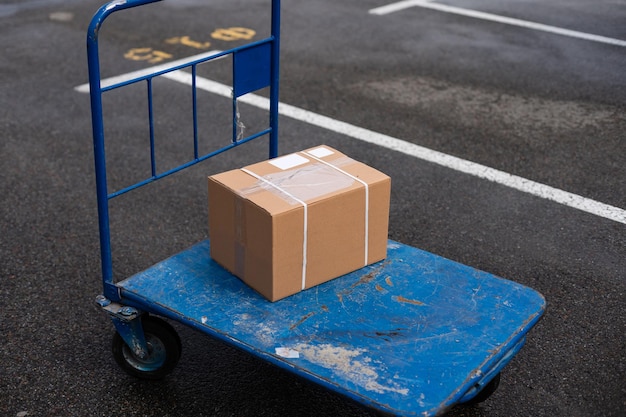 Boîte de déménagement en carton brun dans le chariot.