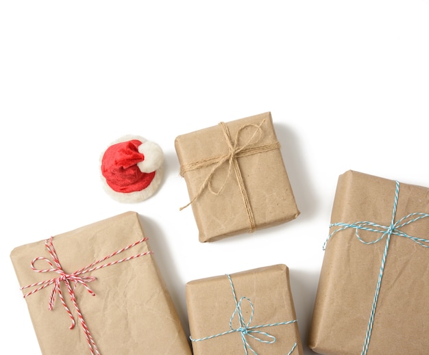 Boîte enveloppée dans du papier brun et attachée avec une corde, cadeau sur blanc, vue du dessus