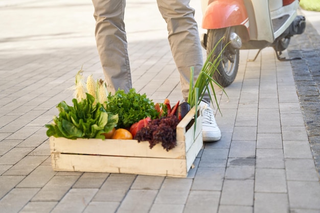 Boîte d'épicerie en bois avec des légumes frais debout dans la rue