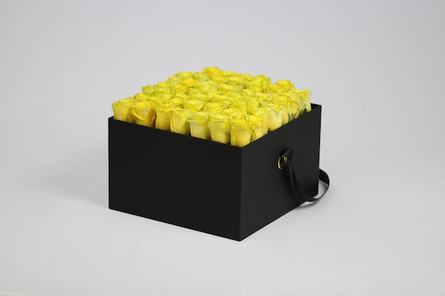 Boîte à fleurs carrée noire avec des roses jaunes à l'intérieur