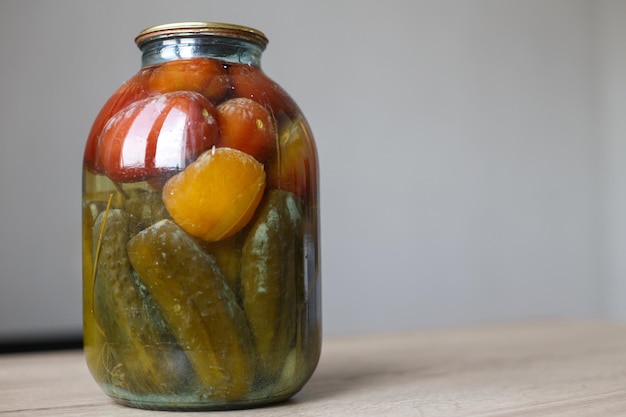 Boîte gâtée de couture de légumes. Bocal en verre avec tomates marinées maison et concombres avec champignon blanc