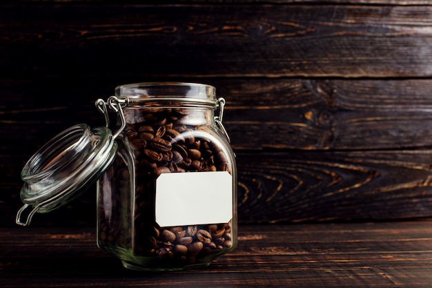 Une boîte de grains de café se dresse sur une table en bois.