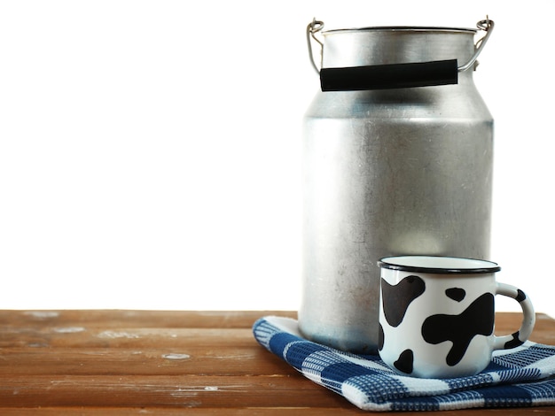 Boîte de lait rétro et tasse de lait sur table en bois sur fond blanc