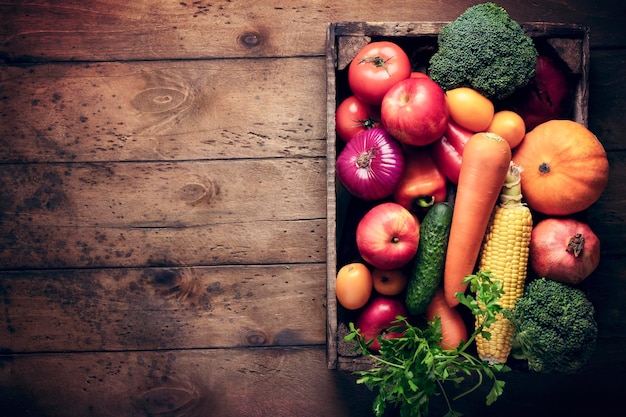 Une boîte avec des légumes frais récolte des fruits sur une table en bois vide cuisine de fond rustique recettes d'aliments sains organiques et vitamines