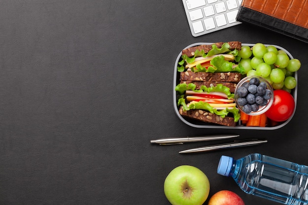 Boîte à lunch de bureau saine avec sandwich et légumes frais