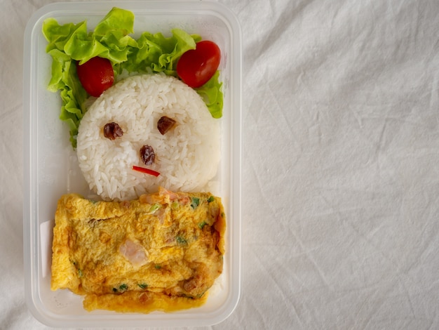 Boîte à lunch décorée de riz avec une omelette asiatique.