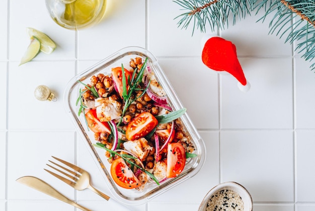 Boîte à lunch avec salade tiède au poulet grillé pois chiches épicés tomate et roquette