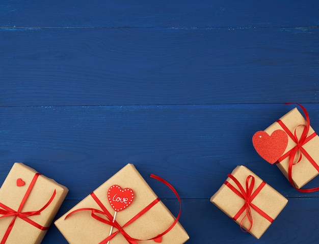 Boîte marron avec un cadeau et un coeur en papier rouge