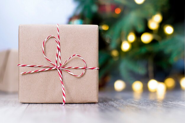 Boîte de Noël avec un cadeau sur le fond de l'arbre de Noël