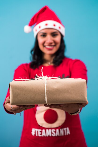 Boîte de Noël enveloppée de papier kraft sur les mains de la femme