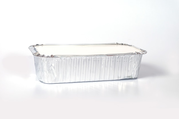 Boîte de nourriture en aluminium sur fond blanc.