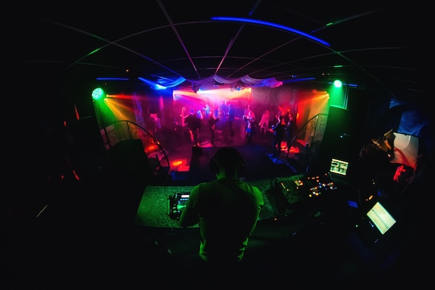 Boîte de nuit avec DJ mixant de la musique et des gens dansant en discothèque