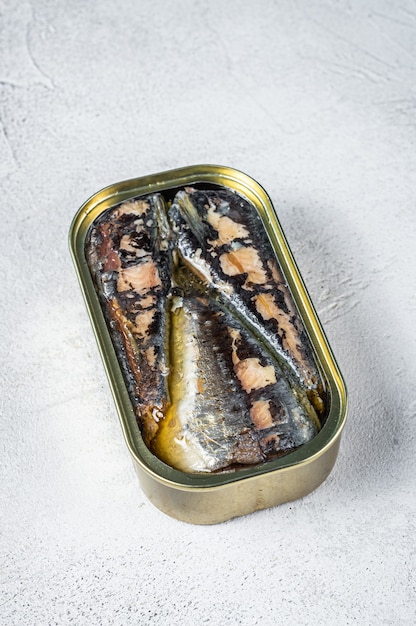 Boîte ouverte avec sardine à l'huile d'olive. Fond blanc. Vue de dessus.