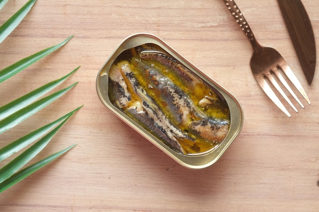 Boîte ouverte de sardines sur fond de carreaux blancs