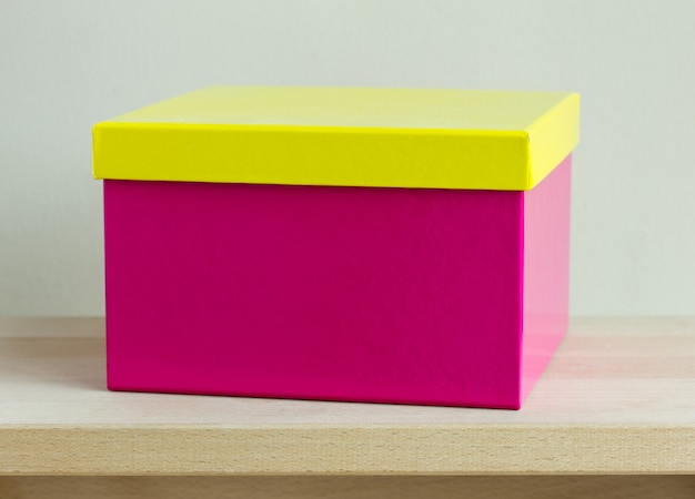 Boîte en papier coloré blanc sur table en bois