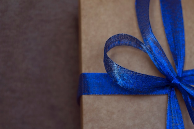 Boîte présente avec noeud de ruban bleu sur fond textile doux avec gros plan