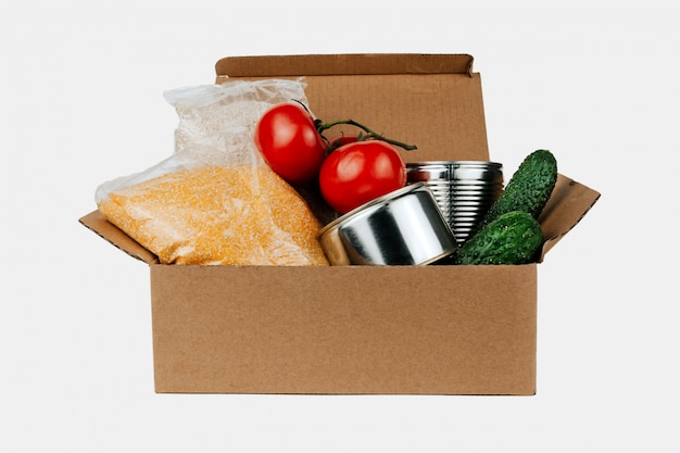 Boîte avec produits. Légumes, céréales et conserves dans une boîte en carton isolée.