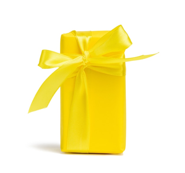 Boîte rectangulaire avec un cadeau emballé dans du papier jaune et noué avec un ruban de soie jaune