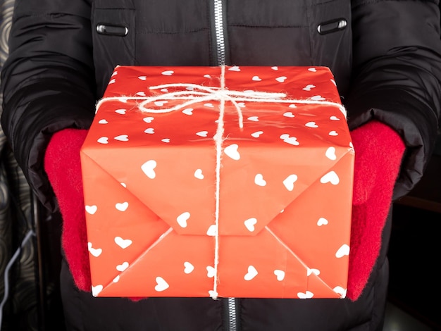 Boîte rouge cadeau Saint Valentin à la main, offrez un cadeau pour le nouvel an.