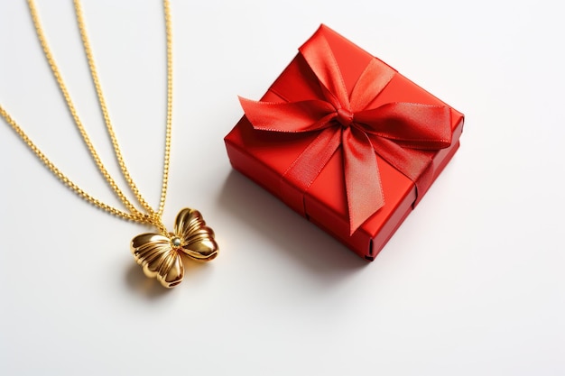 Photo une boîte rouge ornée d'un nœud est assise à côté d'un collier d'or étincelant la boîte est fermée mettant en évidence le collier brillant enveloppé autour d'elle isolé sur un fond transparent png
