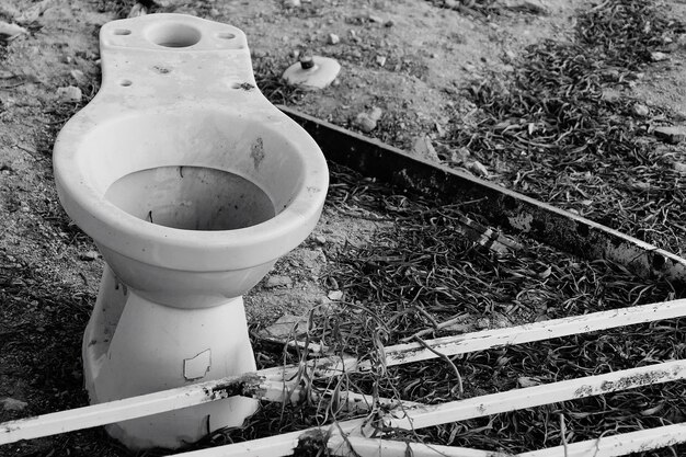 Photo boîte de toilette abandonnée sur le terrain par une balustrade métallique rouillée