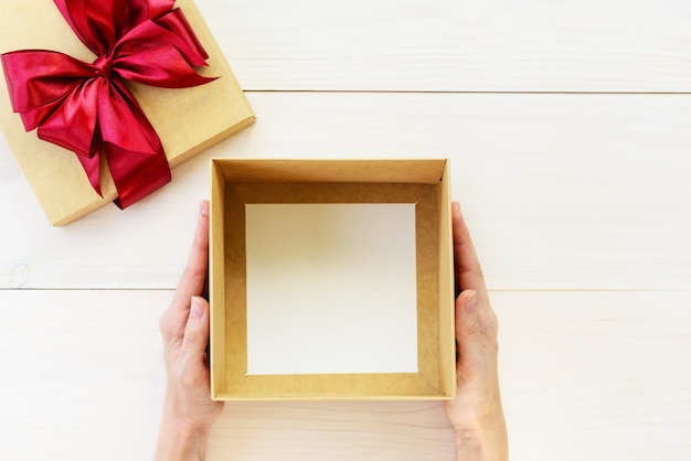 Boîte vide pour un cadeau entre les mains d'un homme. Orientation horizontale, vue de dessus, espace de copie.