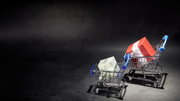 Boîtes à bijoux en gros plan dans un chariot de supermarché miniature, isolé sur un fond sombre