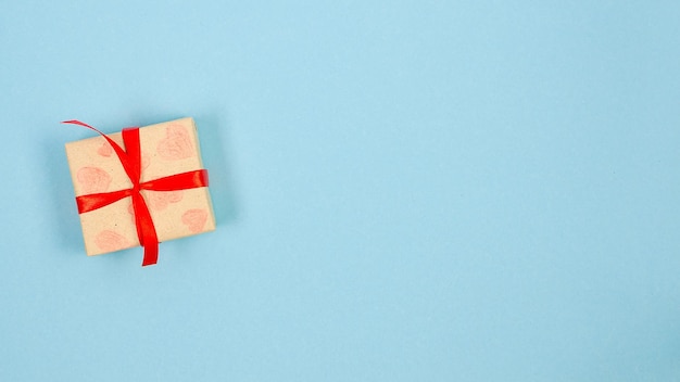 Boîtes cadeaux dans du papier d'emballage noué un ruban rouge sur fond bleu