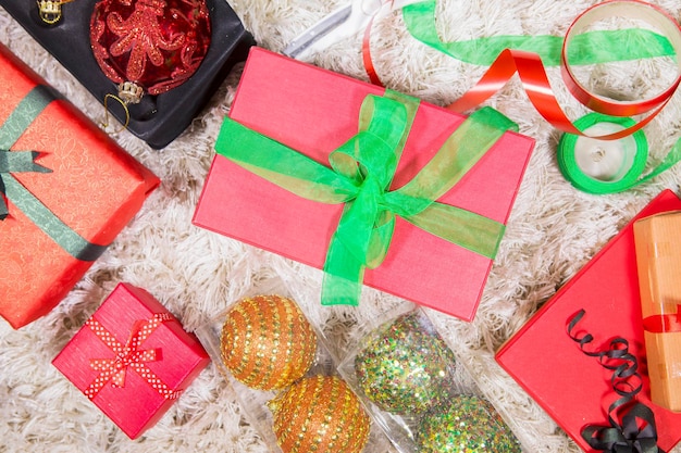 Des boîtes de cadeaux avec des ornements de Noël sur le tapis.