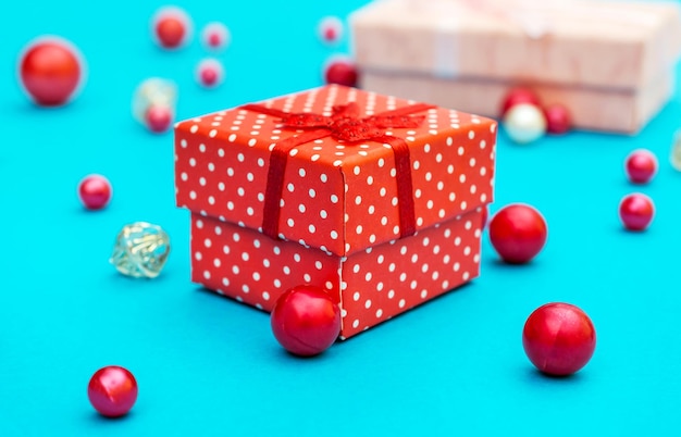 Des boîtes cadeaux avec des perles rouges sur fond bleu de vacances