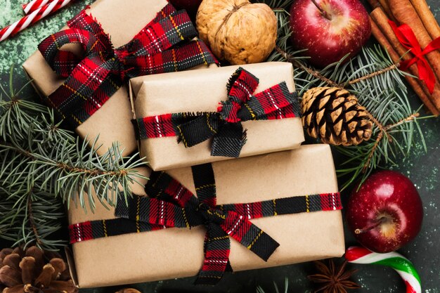 Boîtes avec des cadeaux pour Noël et divers attributs de vacances sur une surface verte. Vue de dessus