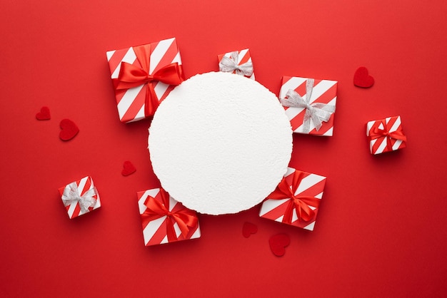 Boîtes avec des cadeaux pour la saint valentin et carte de voeux ou texte publicitaire sur fond rouge avec des coeurs