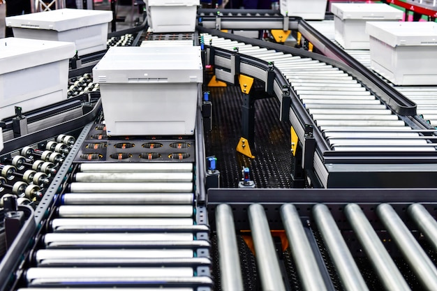 Boîtes en carton blanc sur la bande transporteuse. Concept de système de transport de colis