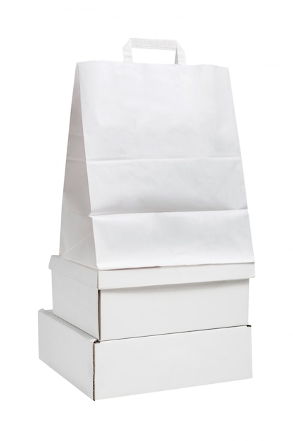 Boîtes en carton blanc vierge et sac blanc isolé sur fond blanc. Concept de livraison d'emballage