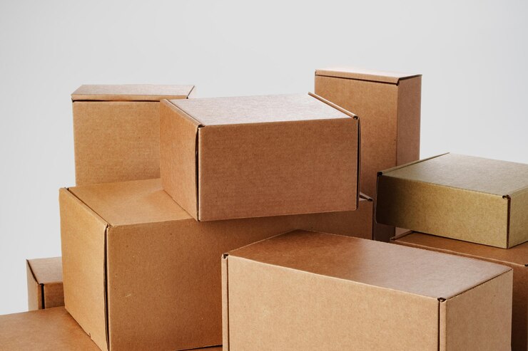 Photo des boîtes de carton brun empilées de différentes tailles disposées sur un fond blanc