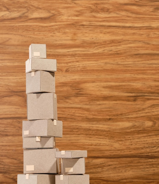 Des boîtes en carton de différentes tailles debout verticalement près d'un mur en bois Le thème se déplace dans une nouvelle maison Copier l'espace pour le texte