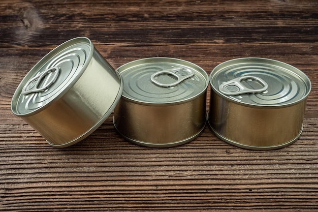 Boîtes de conserve avec de la nourriture sur une table en bois