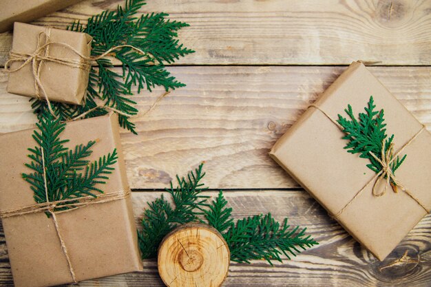 Boîtes emballées avec du papier kraft et de la ficelle naturelle sur un fond en bois. Le concept de Noël et du nouvel an.