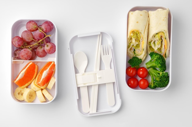 Boîtes à lunch avec des aliments sains isolés sur blanc