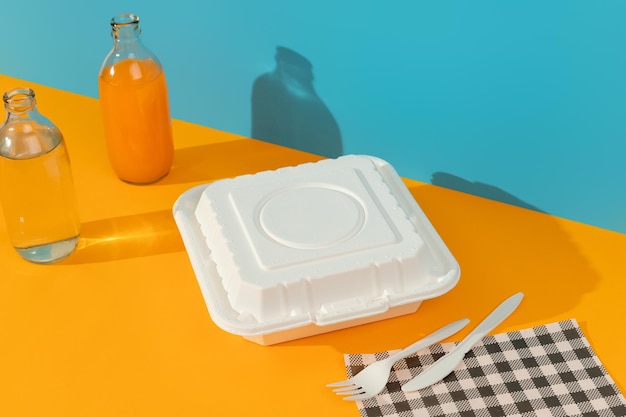 Boîtes à lunch couverts et boissons sur le concept de livraison de nourriture de table orange