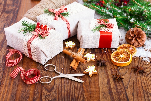 Boîtes à la main de Noël et branche avec de la neige