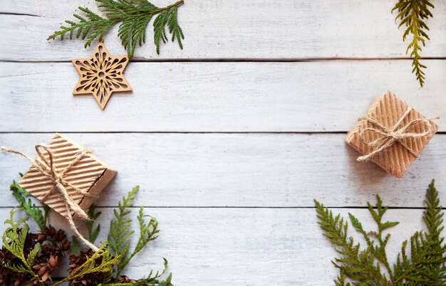 Boîtes en papier et branches vertes sur fond de bois blanc