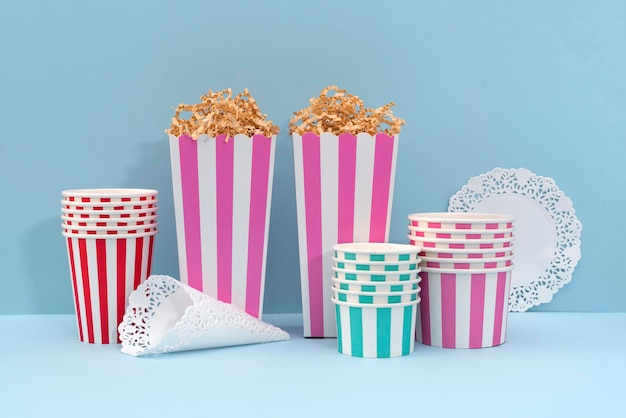 Photo des boîtes de popcorn en papier rose vides un ensemble de vaisselle en papier jetable sans plastique fond bleu