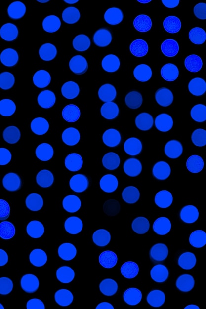 Bokeh abstrait bleu foncé flou sur fond noir. défocalisé et flouté de nombreuses lumières rondes.