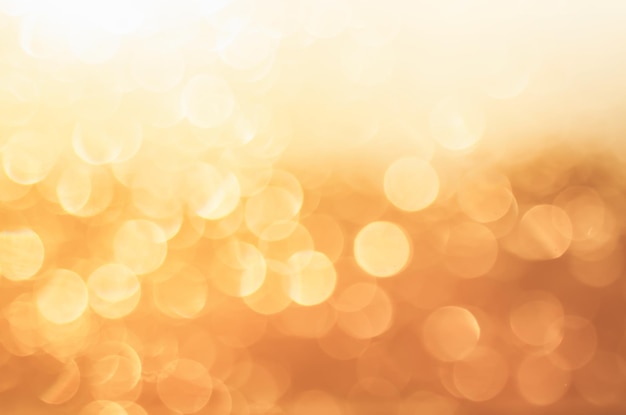 Bokeh abstrait de lumière de paillettes brillantes de Noël dans des couleurs dorées, arrière-plan flou de vacances saisonnières. Concept rétro vintage hipster