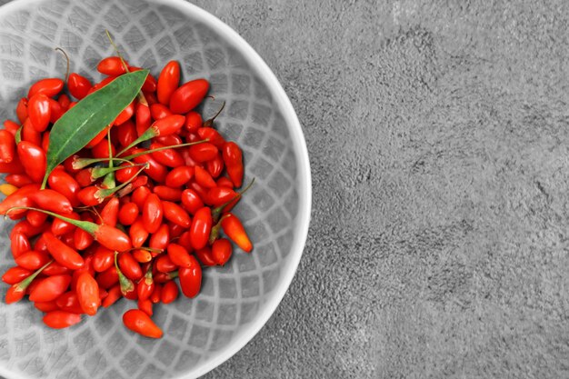 Photo bol avec des baies de goji fraîches sur table