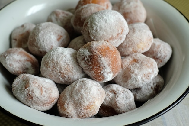 un bol de beignets en poudre avec du sucre en poudre