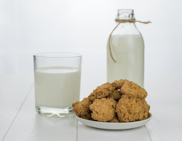 Bol avec des biscuits faits maison de farine et de lait sur une table en bois blanche.